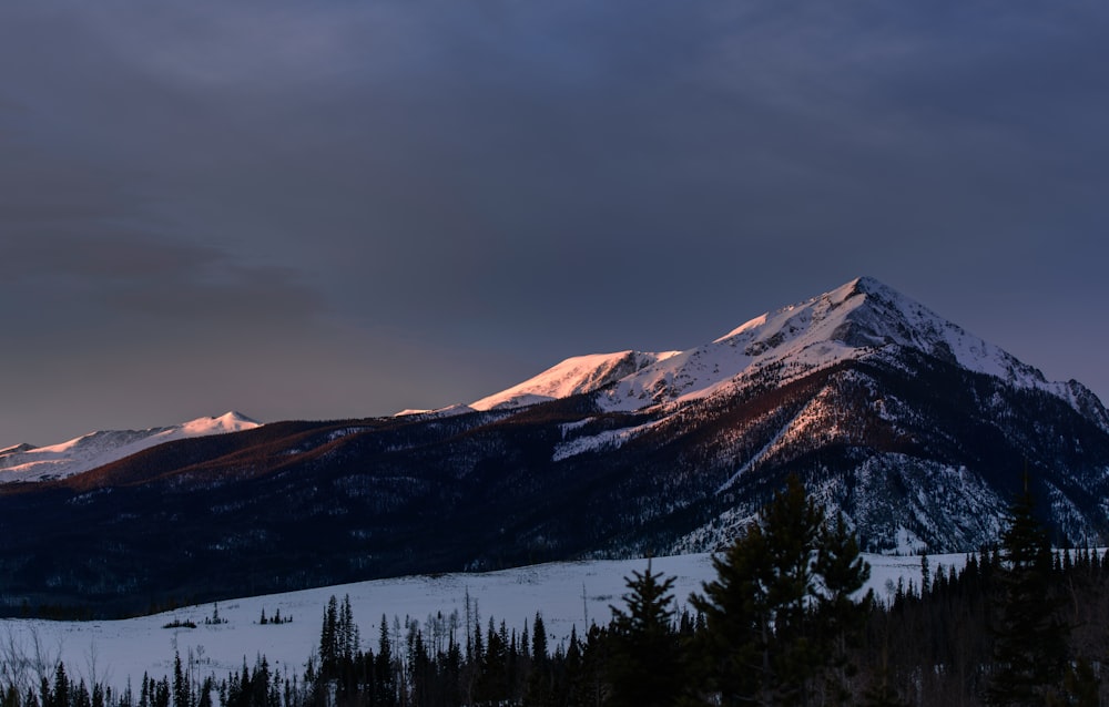 Montanha nevada sob céu nublado