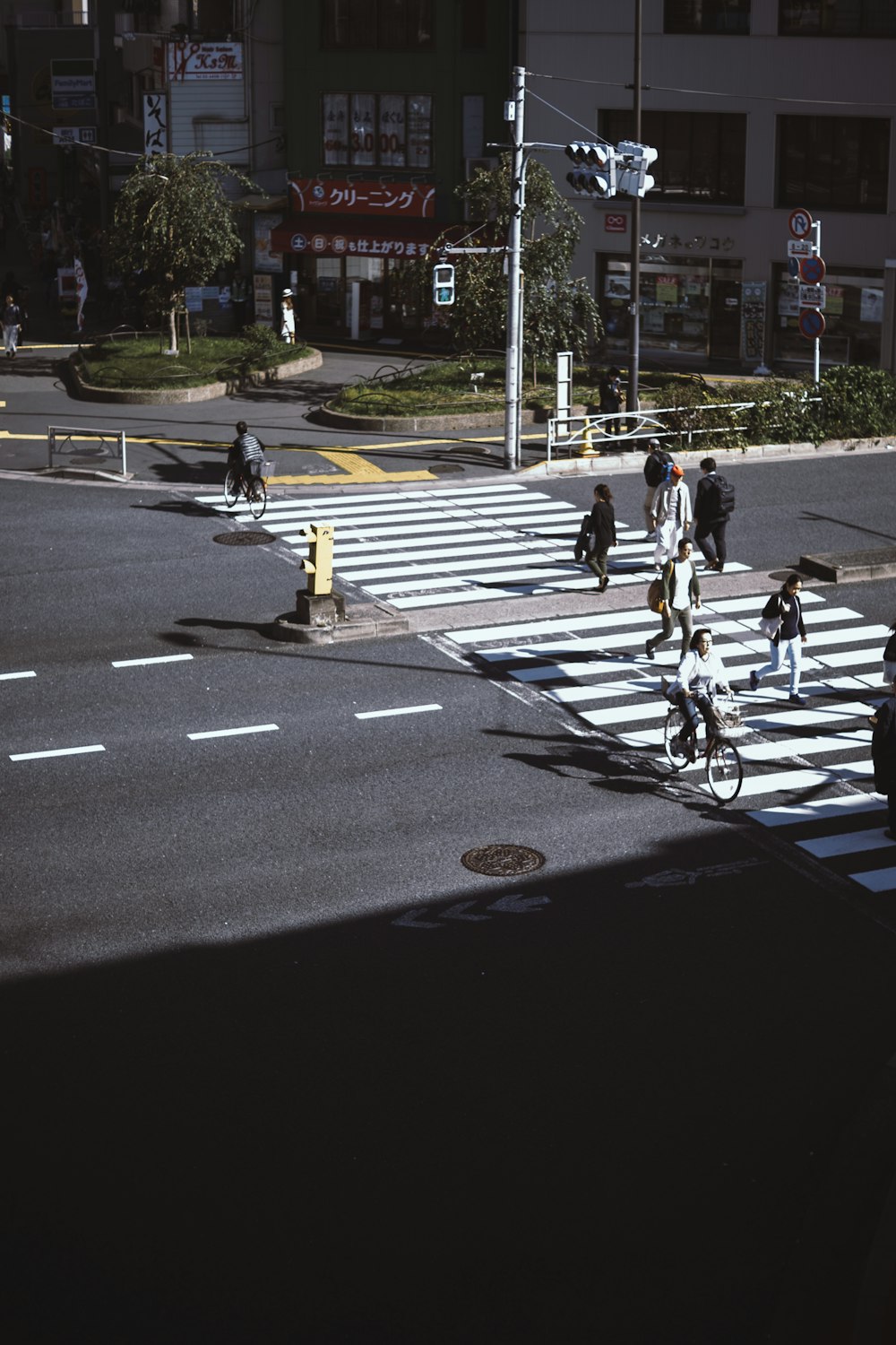 personas que caminan por el carril peatonal a través de la carretera durante el día