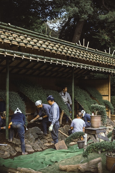 A diverse group of volunteers smiling and working together outdoors in a community garden.