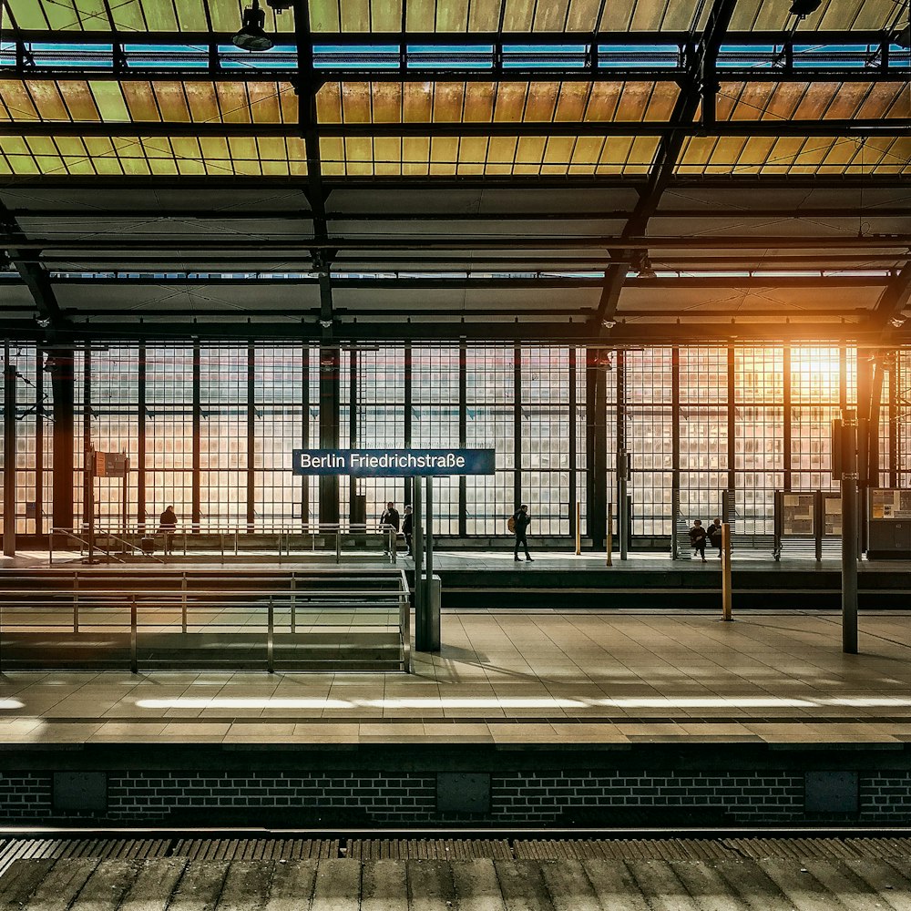 people standing inside station during golden hour