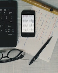 Flat lay of a turquoise and orange themed workspace with music notes and a tablet.