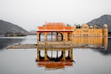 brown concrete building surrounded by water during daytime
