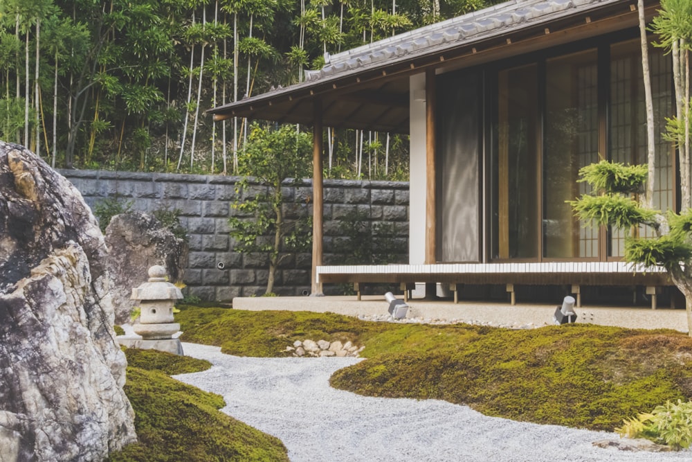 Casa de madera con puerta corredera de vidrio junto a los árboles durante el día