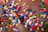 A close-up of a vibrant vegan donut with colorful sprinkles on a rustic wooden table.