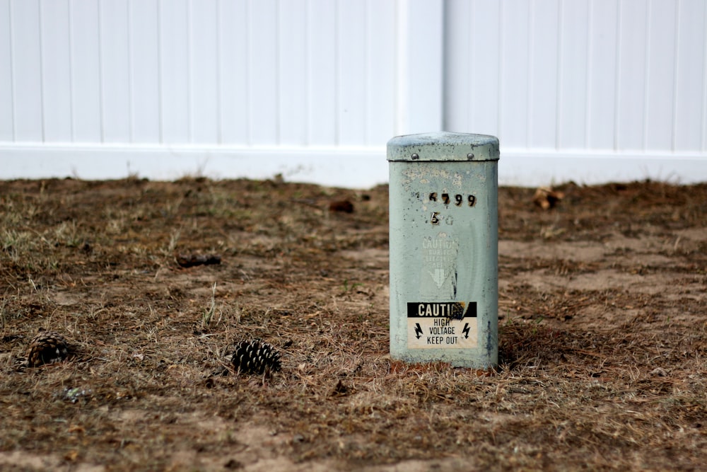 gray trash bin on brown grass