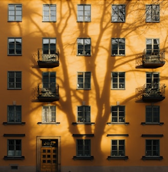 orange concrete building with tree shadow during daytime