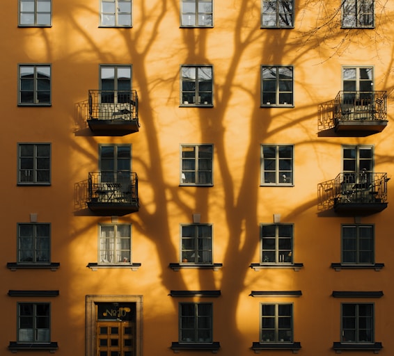 orange concrete building with tree shadow during daytime