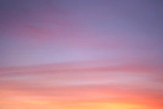 A serene horizon at sunrise with soft pastel colors blending into the sky.