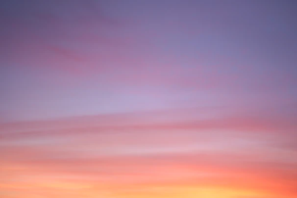 A serene yoga session at sunrise with soft purple and gold hues blending into the sky.