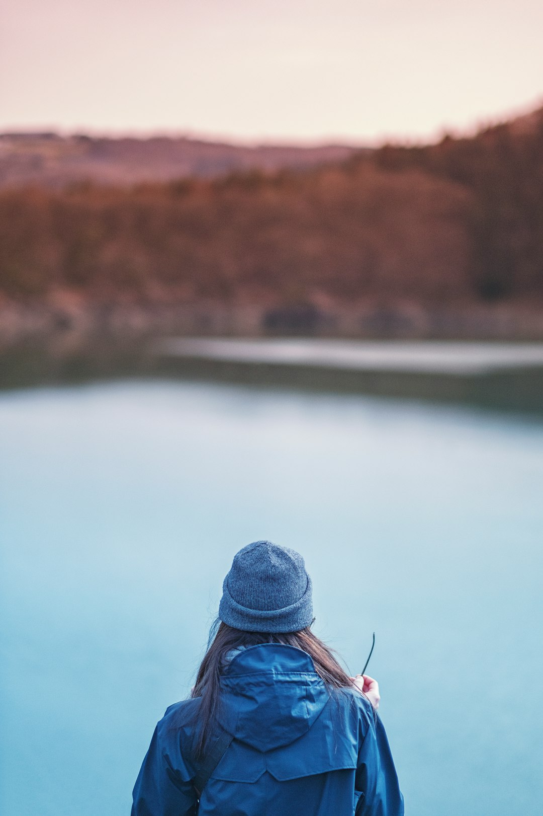 woman standing in front of lake selective focus photo