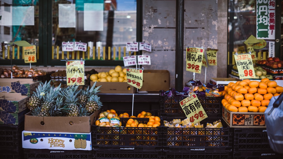 assorted fruits with labels on crates