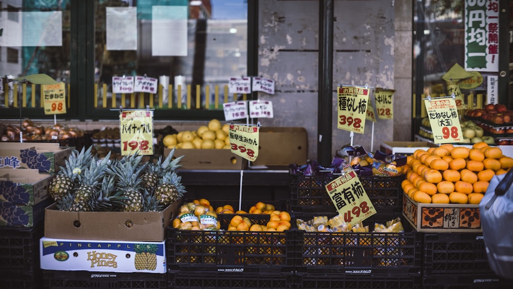 assorted fruits with labels on crates