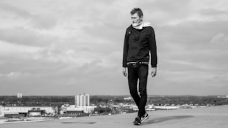 Casual outfit featuring layered hoodies and accessories styled on a city rooftop.