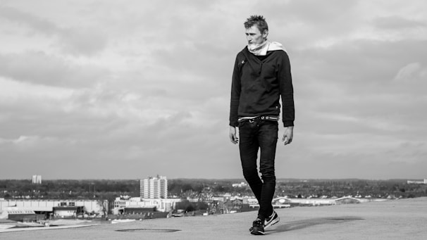 Casual outfit featuring layered hoodies and accessories styled on a city rooftop.