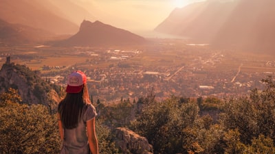 woman wearing gray shirt facing town near mountain during daytime view google meet background