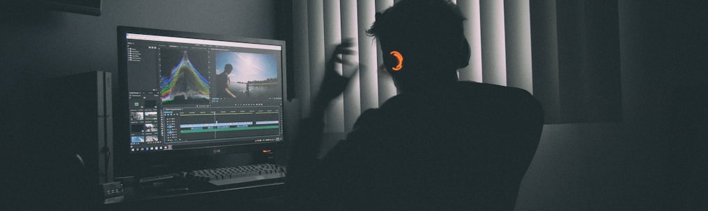 shallow focus photography of man listing to music in front of the computer