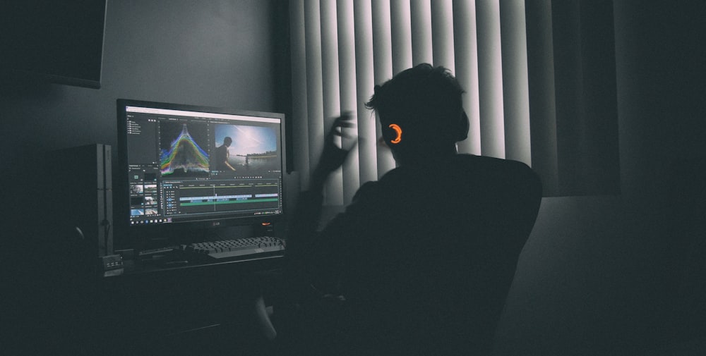 컴퓨터 앞에서 음악을 듣는 남자의 얕은 초점 사진