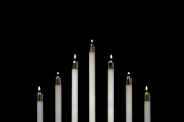 seven white candles closeup photography