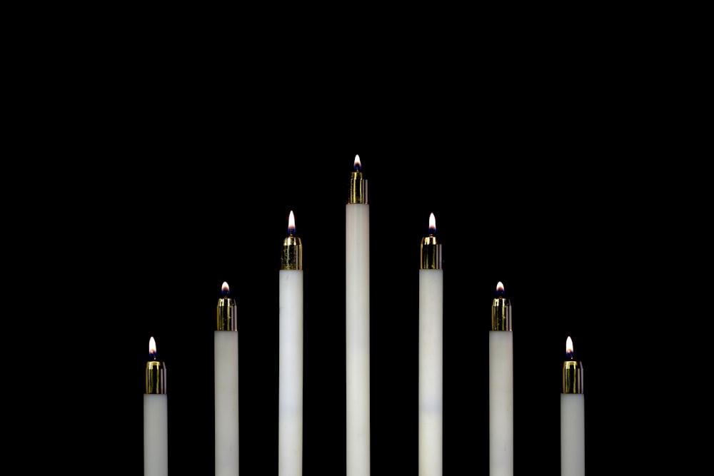 Photographie en gros plan de sept bougies blanches