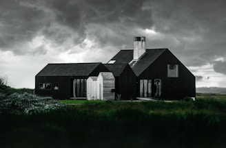 A sturdy, modern home surrounded by lush greenery under a cloudy sky, symbolizing strength against storms.
