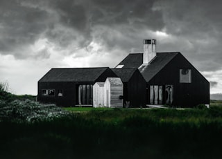 black and white house beside green grass field