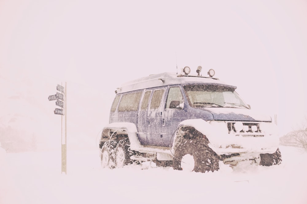 blauer SUV mit Schnee bedeckt