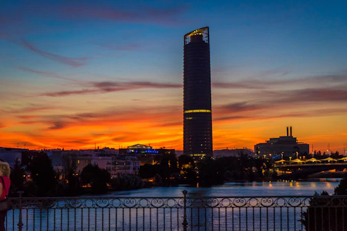 A modern apartment building overlooking the Nile River at sunset.