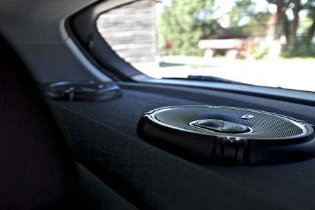 Interior view of a sports car showcasing a clean, professional car audio installation with visible wiring and amplifier.