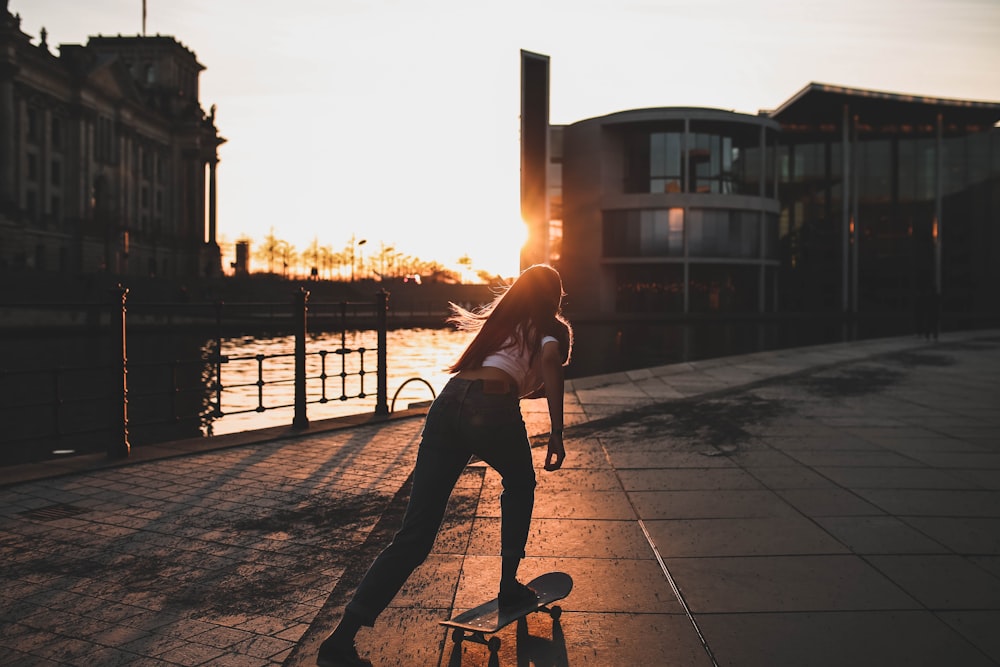 Mujer jugando a la patineta cerca del río durante el día