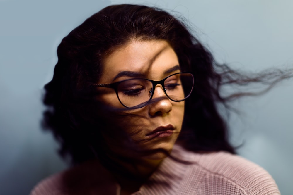 selective photography of woman wearing gray knit top and black framed eyeglasses