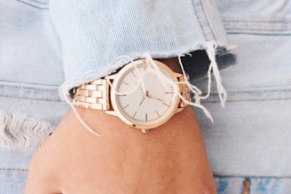 Women wearing an analog watch pointing at 9:45