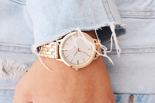 Women wearing an analog watch pointing at 9:45