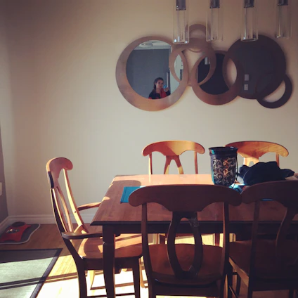 A cozy wooden dining table set with matching chairs bathed in warm natural light.