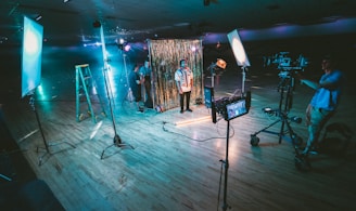 man standing in front of cameras with string lights background