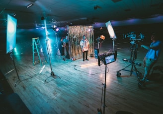 man standing in front of cameras with string lights background