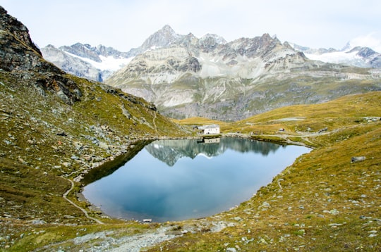 lake and snow covered mountain during daytime in Lake Schwarzsee Switzerland