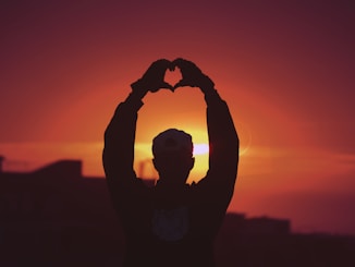 silhouette of man raising his hands