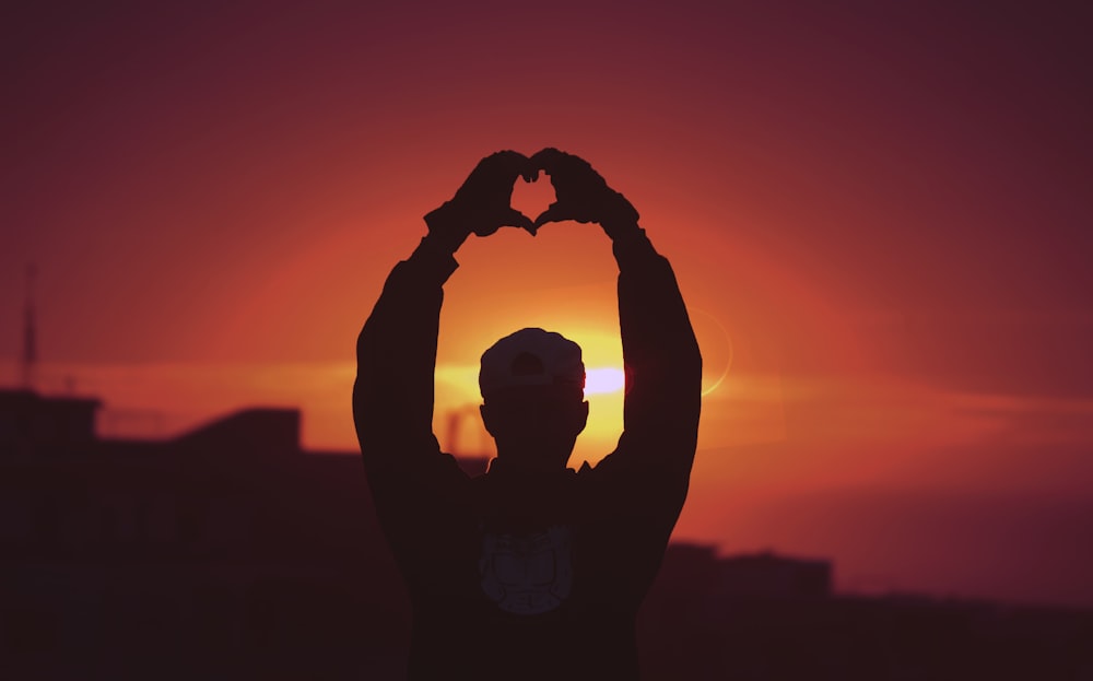 silhouette of man raising his hands