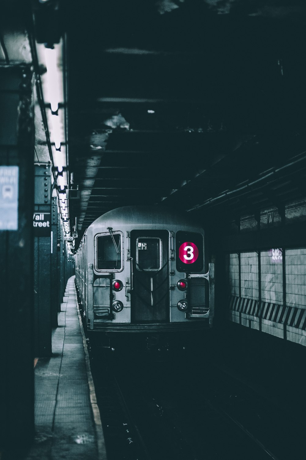 selective color photo of a subway station with train