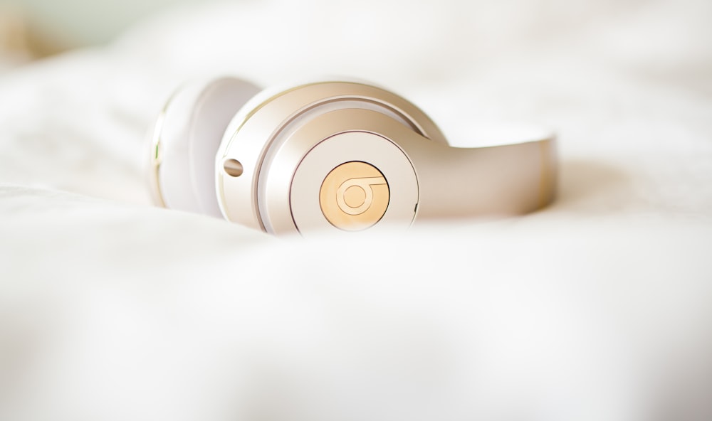 gold edition Beats by Dr.Dre wireless headphones on top of white textile