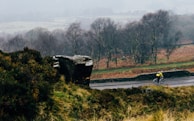 man riding bike on countryside concrete road during foggy day