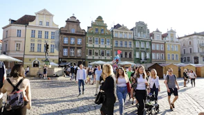 A peaceful town square bustling with characters in colorful Ragnarok attire