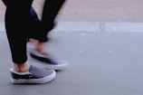 Stylish young person wearing black and grey Nike sneakers walking on Madrid pavement