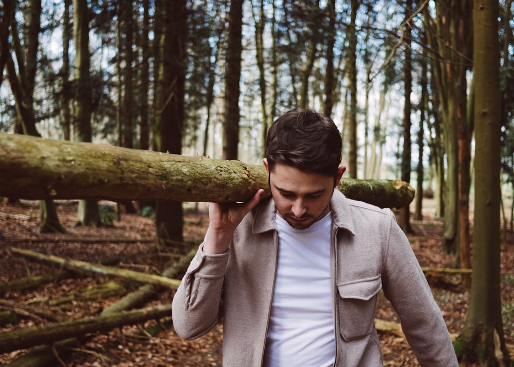 man carrying wood log