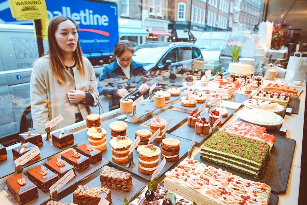 woman facing cake displays