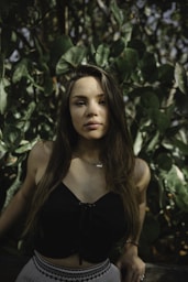 lowlight photography of woman in black crop top near plants