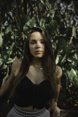 lowlight photography of woman in black crop top near plants