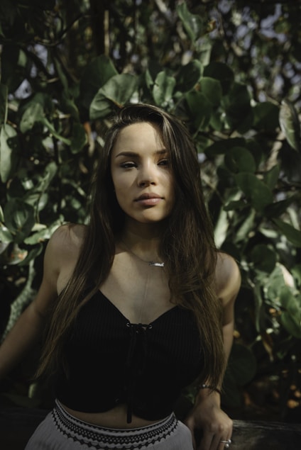 lowlight photography of woman in black crop top near plants