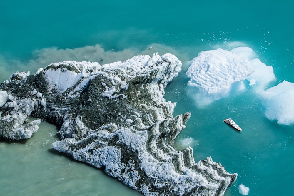 Weißes Kreuzfahrtschiff fährt an weißer und grauer Insel vorbei