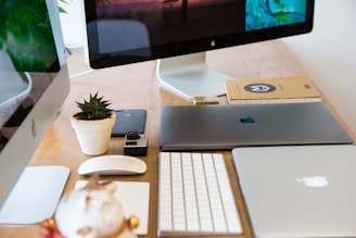 A Windows laptop with multiple external monitors, keyboard, and mouse arranged neatly on a dark gray desk, emphasizing a focused work environment.